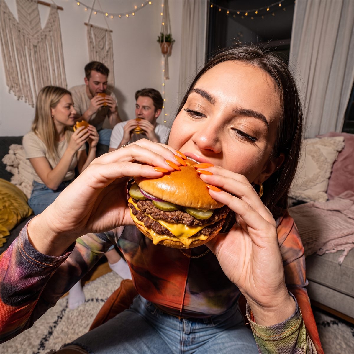Klientka je burgera CITY BURGER, w tle ekipa